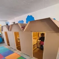 Niñas y niños jugando en una casita de aprendizaje